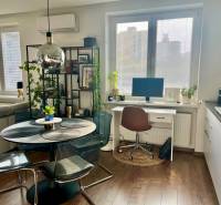 Prenájom 2,5 izbový byt, Trenčianska ulica, Bratislava II. Ružinov - Jedáleň s okrúhlym stolom, pracovný kút a podlaha s dreveným dekorom v 2-izbovom byte.