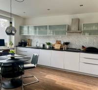 Prenájom 2,5 izbový byt, Trenčianska ulica, Bratislava II. Ružinov - Kuchyňa v 2-izbovom byte s podlahou s dreveným dekorom a jedálenským stolom.