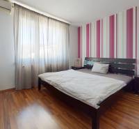 Predaj, 4izbový byt  Fončorda, Banská Bystrica - Spálňa s pruhovanou stenou, posteľou, komodou a podlahou s dreveným dekorom v 4-izbovom byte.
