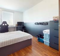 Predaj, 4izbový byt  Fončorda, Banská Bystrica - Spálňa so stolom a pohodlným kreslom v 4-izbovom byte, podlaha s dreveným dekorom.