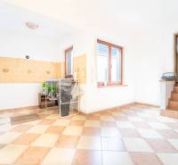 RD PO REKONŠTRUKCII spolu so STAVEBNÝM POZEMKOM na druhý dom - takmer  - Interiér rodinného domu s dlažbou a kuchynským kútom.