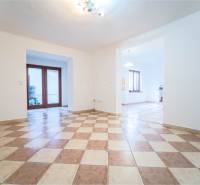 RD PO REKONŠTRUKCII spolu so STAVEBNÝM POZEMKOM na druhý dom - takmer  - Priestranná miestnosť v rodinnom dome s kachličkovou podlahou a drevenými dverami na terasu.