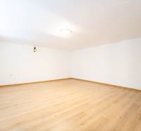 RD PO REKONŠTRUKCII spolu so STAVEBNÝM POZEMKOM na druhý dom - takmer  - Priestranná miestnosť v rodinnom dome s bielymi stenami a podlahou s dreveným dekorom.