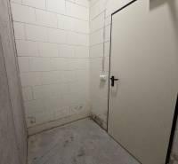 Komfortne vybavený 2-izbový byt v projekte 2 Sýpky - Malá miestnosť s betónovou podlahou a bielymi tehlovými stenami v 2-izbovom byte.