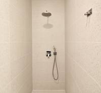 Komfortne vybavený 2-izbový byt v projekte 2 Sýpky - Sprchový kút s bielym obkladom v 2-izbovom byte.