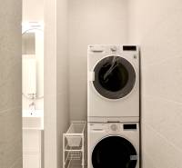Komfortne vybavený 2-izbový byt v projekte 2 Sýpky - Práčka a sušička v úzkej kúpeľni, vedľa skrinky s umývadlom v 2-izbovom byte.