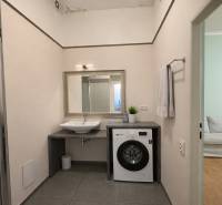 Predaj 4+1 izbový byt, 110 m2, 2 balkóny, Obchodná ul, centrum BA - Kúpeľňa v 4-izbovom byte s umývadlom, práčkou, zrkadlom a vstupom do obývačky.
