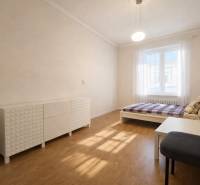 Predaj 4+1 izbový byt, 110 m2, 2 balkóny, Obchodná ul, centrum BA - Spálňa so svetlým nábytkom, posteľou, kreslom a podlahou s dreveným dekorom v 4-izbovom byte.
