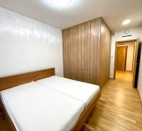 I 3 i byt s parkovaním v rezidenčnom komplexe METROPOLIS - Spálňa v 3-izbovom byte s podlahou s dreveným dekorom a vstavanou skriňou.