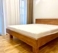 I 3 i byt s parkovaním v rezidenčnom komplexe METROPOLIS - Spálňa v 3-izbovom byte s posteľou a podlahou s dreveným dekorom.