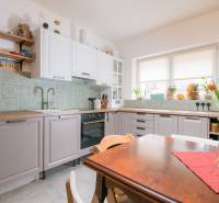 Na predaj zrekonštruovaný dom na Štefánikovej ulici, Trenčín - Rodinný dom: Kuchyňa s kvetinovou výzdobou a dekoratívnymi obkladačkami na stene.