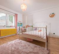 Na predaj zrekonštruovaný dom na Štefánikovej ulici, Trenčín - Detská izba v rodinnom dome s podlahou s dreveným dekorom a ružovými doplnkami.