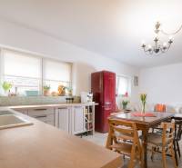 Na predaj zrekonštruovaný dom na Štefánikovej ulici, Trenčín - Kuchyňa v rodinnom dome s červenou chladničkou, dreveným stolom a pohovkou.