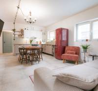 Na predaj zrekonštruovaný dom na Štefánikovej ulici, Trenčín - Obývacia izba a kuchyňa v rodinnom dome s jedálenským stolom a červenou chladničkou.