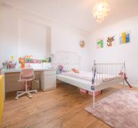 Na predaj zrekonštruovaný dom na Štefánikovej ulici, Trenčín - Detská izba v rodinnom dome s podlahou s dreveným dekorom a svetlým nábytkom.