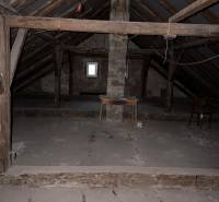 Na predaj zrekonštruovaný dom na Štefánikovej ulici, Trenčín - Podkrovie v rodinnom dome so surovými drevenými trámami a úložným stolom.