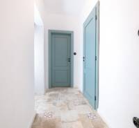 Na predaj zrekonštruovaný dom na Štefánikovej ulici, Trenčín - Chodba v rodinnom dome s modrými dverami a dlažbou s dekorom.