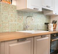 Na predaj zrekonštruovaný dom na Štefánikovej ulici, Trenčín - Kuchyňa v rodinnom dome s vintage obkladom a dreveným dekorom pracovnej dosky.