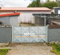 PRAKTICKÉ SKLADOVÉ PRIESTORY  | DOPRAVNÁ | TOPOĽČANY - Dvojkrídlová brána na ulici Dopravná, vedľa sklady a haly, s otvorom 400 cm.