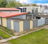 PRAKTICKÉ SKLADOVÉ PRIESTORY  | DOPRAVNÁ | TOPOĽČANY - Budovy na ulici Dopravná s červenými strechami, skladové haly obklopené zeleňou a stromami.