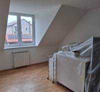 PREDAJ – 4-izbový rodinný dom v radovej zástavbe s garážou - Miestnosť v rodinnom dome s oknom, vykurovacím telesom a podlahou s dreveným dekorom.