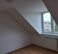 PREDAJ – 4-izbový rodinný dom v radovej zástavbe s garážou - Pokoj pod strechou s oknom a podlahou s dreveným dekorom v rodinnom dome.