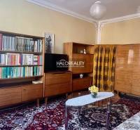 REZERVOVANÉ - Predaj, trojizbový byt Bojnice, Lúčky ... - Obývacia izba v 3-izbovom byte s knihovňou, televízorom a kobercom s kvetinovým vzorom.