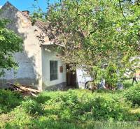 Pôvodný domček v obci Nová Vieska - Rodinný dom v Novej Vieske obklopený zeleňou a stromami, zachytáva pokojnú atmosféru.