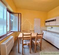 Pôvodný domček v obci Nová Vieska - Kuchyňa v rodinnom dome s dreveným stolom, oknom a skrinkami.