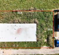 Základová doska na  575 m2 pozemku - Čeľadice  - Pozemky - bývanie v Čeľadiciach: zobrazuje oplotený trávnatý pozemok so stavbou.