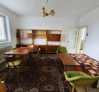 Predaj rodinného domu, Seredská, Seredská, Hlohovec - Rodinný dom so starožitným nábytkom, kobercom s farebnými vzormi a zelenými stoličkami.