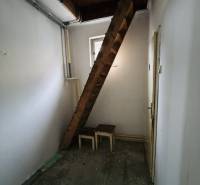 Predaj rodinného domu, Seredská, Seredská, Hlohovec - Úzka izba s dreveným schodiskom a oknom v rodinnom dome.