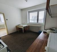 Predaj rodinného domu, Seredská, Seredská, Hlohovec - Kuchyňa s plynovým sporákom a kobercom v Rodinnom dome, biely interiér, stôl, okno so žalúziami.