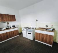 Predaj rodinného domu, Seredská, Seredská, Hlohovec - Kuchyňa s plynovým sporákom, mikrovlnkou a skrinkami v rodinnom dome s dreveným dekorom.