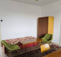 Predaj rodinného domu, Seredská, Seredská, Hlohovec - Izba rodinného domu s kreslami, stolmi, skrinkou a podlahou s dreveným dekorom.