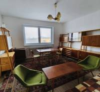 Predaj rodinného domu, Seredská, Seredská, Hlohovec - Obývacia izba v rodinnom dome s retro nábytkom a podlahou s dreveným dekorom.