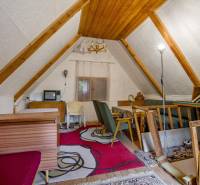 NA PREDAJ CHATA V REKREAČNEJ OBLASTI RUDAVA, OBEC MALÉ LEVÁRE - Podkrovie s drevenými trámami, kobercom a starožitným televízorom v chate.