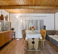 NA PREDAJ CHATA V REKREAČNEJ OBLASTI RUDAVA, OBEC MALÉ LEVÁRE - Interiér chaty s dreveným stropom, pohovkou a jedálenským stolom na podlahe s dreveným dekorom.