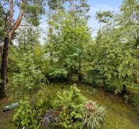 NA PREDAJ CHATA V REKREAČNEJ OBLASTI RUDAVA, OBEC MALÉ LEVÁRE - Záhrada s lavičkou obklopená stromami pri chate v Malých Levároch.