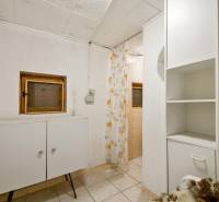 NA PREDAJ CHATA V REKREAČNEJ OBLASTI RUDAVA, OBEC MALÉ LEVÁRE - Interiér chaty s dlažbou, skrinkou a kvetinovým závesom v sprchovom kúte.