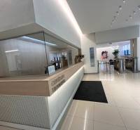 PRENÁJOM exkluzívnych priestorov 318 m2 TECHNOPOL, Kutlíkova ul. - Recepcia v obchodných priestoroch s bielymi stenami a lesklou podlahou.