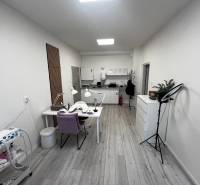 Prenájom ordinácie v zdravotnom stredisku Saratovská 24, Bratislava. - Obchodné priestory s pracovnými stolmi, kreslami, svetlami a podlahou s dreveným dekorom.