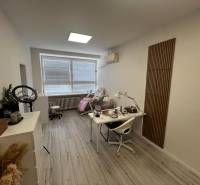 Prenájom ordinácie v zdravotnom stredisku Saratovská 24, Bratislava. - Interiérový priestor s pracovným stolom, stoličkou a podlahou s dreveným dekorom.