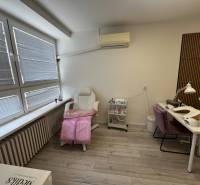 Prenájom ordinácie v zdravotnom stredisku Saratovská 24, Bratislava. - Kozmetický salón s kreslom, stolíkom a podlahou s dreveným dekorom v obchodných priestoroch.