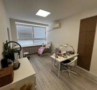 Prenájom ordinácie v zdravotnom stredisku Saratovská 24, Bratislava. - Kozmetický salón s podlahou s dreveným dekorom, bielym nábytkom a jemným osvetlením.