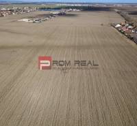 INVESTIČNÁ PRÍLEŽITOSŤ – Pozemok v obci Dunajská Lužná - Rozľahlé poľnohospodárske a lesné pozemky v okolí Dunajskej Lužnej, s viditeľnou obytnou zástavbou.