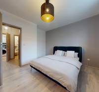 RADO I 2-izbový byt 49m² s terasou 71m² I Soblahov - Spálňa v 2-izbovom byte s lôžkom, podlahou s dreveným dekorom a elegantným svietidlom.