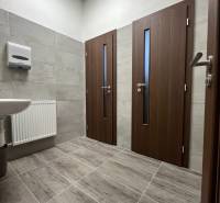 Investičná príležitosť: Polyfunkčná budova 1 000m², Košice-Staré mesto - Interiér budovy s dlažbou, dvermi a umývadlom, jednoduchý dizajn.