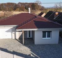 MALÉ LEVÁRE-Predaj  3i modernej novostavby RD s tep. čerpadlom + garáž - Rodinný dom na ulici Malé Leváre v Malých Levároch s červenou strechou a dláždeným dvorom.