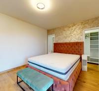 MALÉ LEVÁRE-Predaj  3i modernej novostavby RD s tep. čerpadlom + garáž - Spálňa v rodinnom dome s posteľou, čalúneným čelom a podlahou s dreveným dekorom.